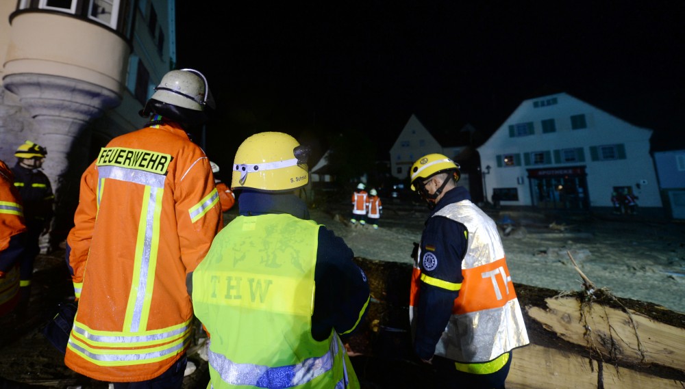 Feuerwehrleute stehen am 30.05.2016 in der Ortsmitte auf einer überfluteten Straße. (Foto: dpa / picture alliance)